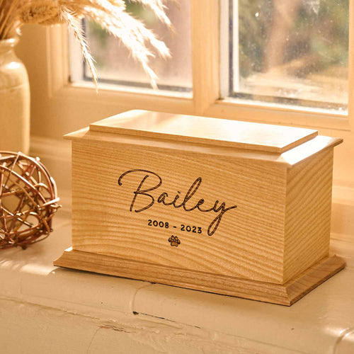 Personalised pet urn made from solid ash wood with pet paw engraving by Thicket Memorials