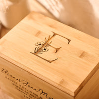 Bamboo wood cremation urn featuring custom floral initial engraving.