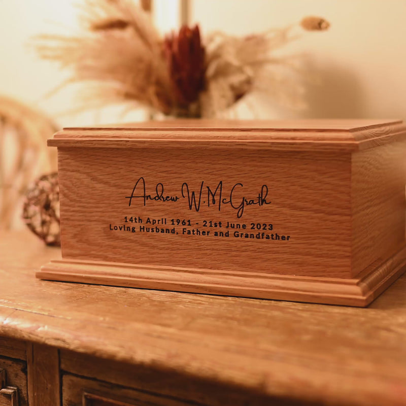 A video showing a wooden cremation urn from different angles. The urn is made of light wood and has a personalised engraving which reads "Andrew W. McGrath - 14th April 1961 - 21st June 2023 - Loving Husband, Father and Grandfather"