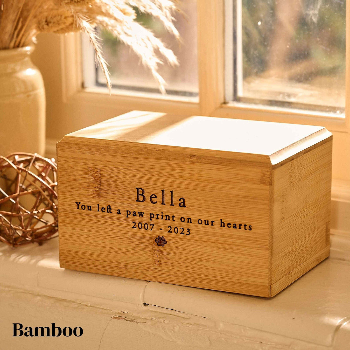 A dog urn or cat urn made from bamboo. It is a cremation urn for pets with a pawprint engraved on it.